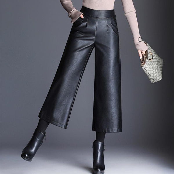 femme portant des bottes avec un pantalon coupe culotte taille haute en simili cuir noir taille élastique