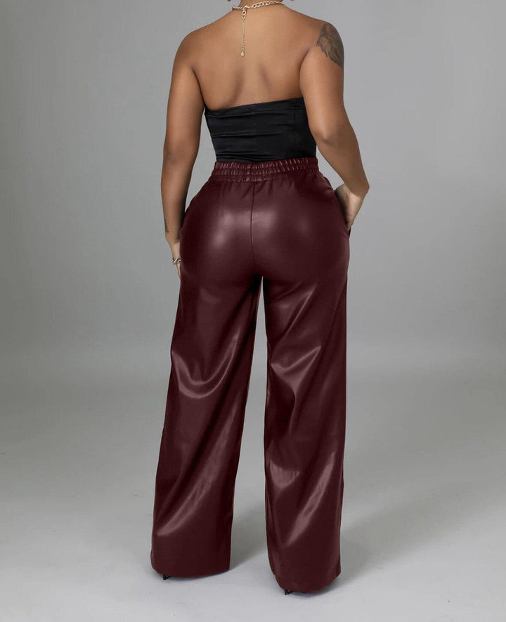 femme de dos portant un haut bandeau avec un pantalon large en simili cuir bordeaux taille haute avec taille élastique
