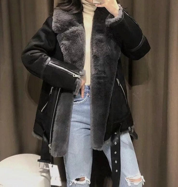 femme portant un jean slim troué avec une manteau double face en simili cuir et fourrure noir