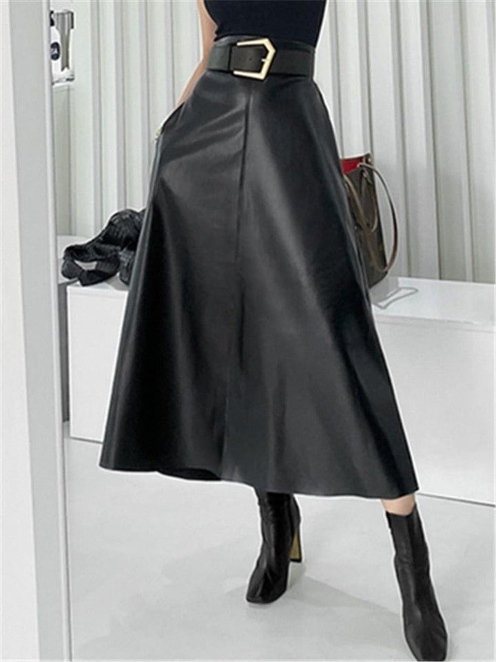 femme portant des bottines à talons avec une jupe longue mi mollet e simili cuir noir avec une ceinture avec une boucle argentée