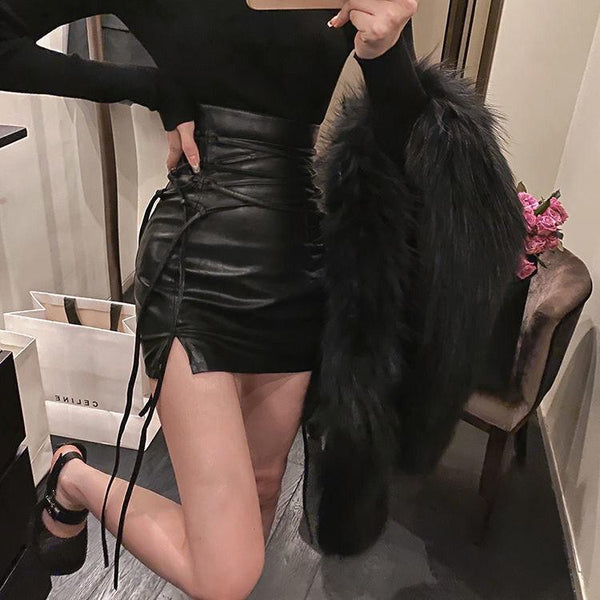 femme porte une mini jupe en simili cuir noire fendue avec de longs lacets qui resserrent la jupe