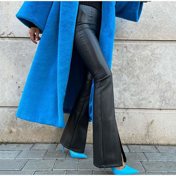 femme portant un long manteau bleu avec un pantalon en simili cuir noir évasé et fendu sur le devant de la jambre