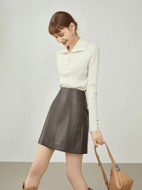 femme portant un pull blanc, un sac marron et une mini jupe droite en simili cuir marron