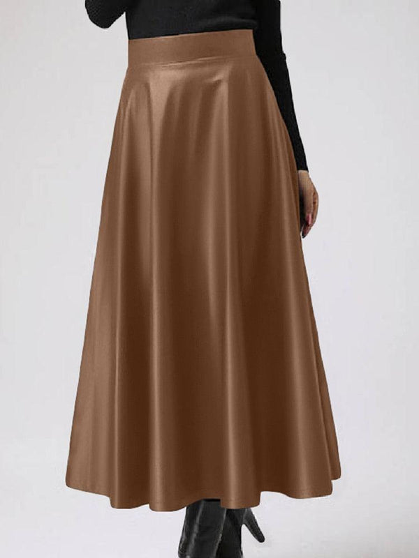 femme portant une jupe marron en simili cuir évasée et taille haute avec un haut noir