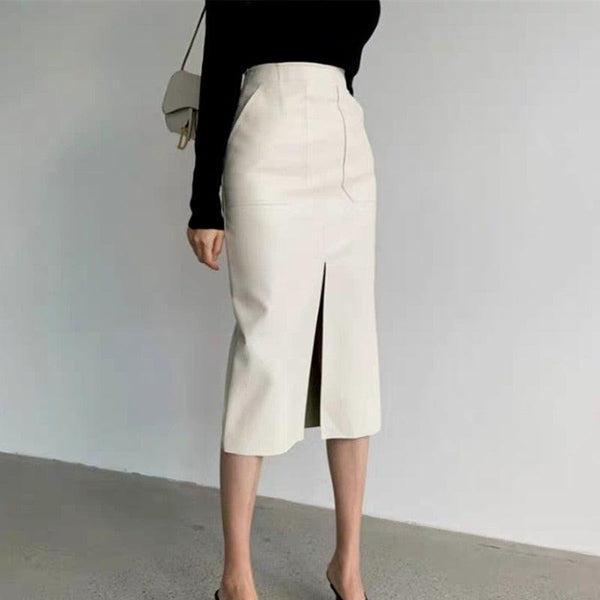 femme en talons portant une jupe crayon taille haute et mi longue avec une fente centrale en simili cuir blanc
