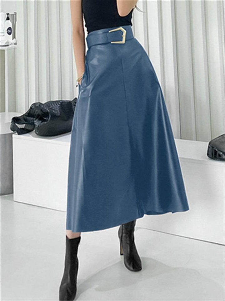 femme portant des bottines à talons avec une jupe longue mi mollet en simili cuir bleue avec une ceinture avec une boucle argentée
