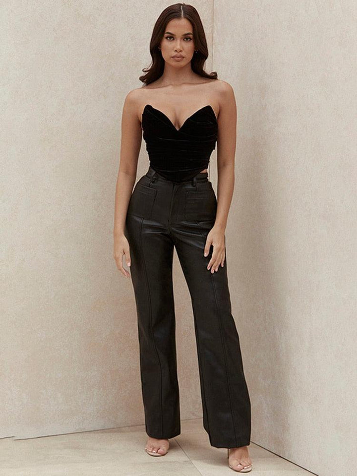 femme brune avec un haut bustier et un pantalon en simili cuir noir aux poches apparentes et taille haute